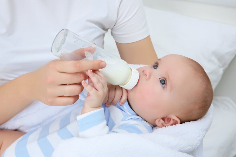 bébé boit un biberon