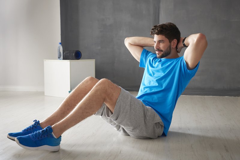 homme qui fait des crunchs pour perdre ses poignées d'amour