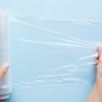 Femme tenant un film alimentaire sur le ventre