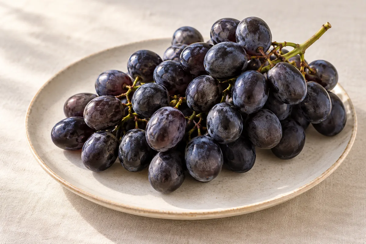 Raisin noir Muscat cru sur un fond de lin clair.
