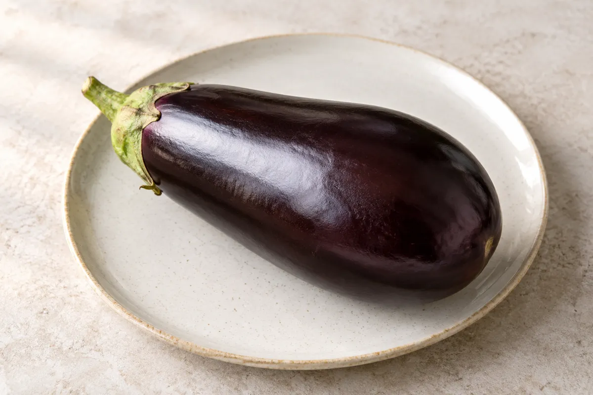 Aubergine sur un fond de lin clair.