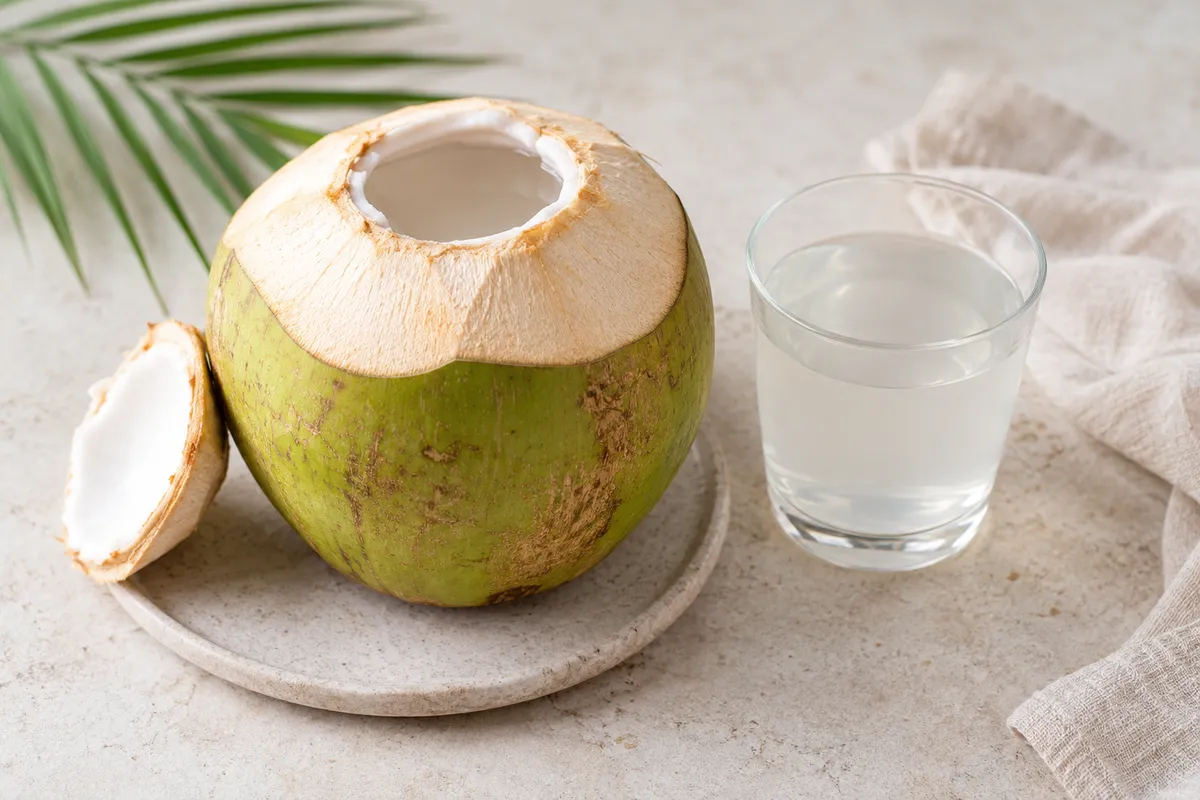 Eau de coco sur un fond de lin clair.